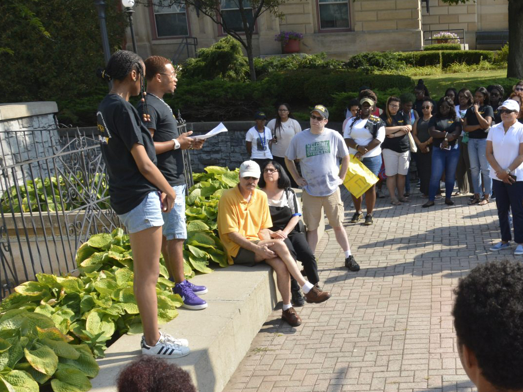 Students speaking outside to a crowd of gathered people.