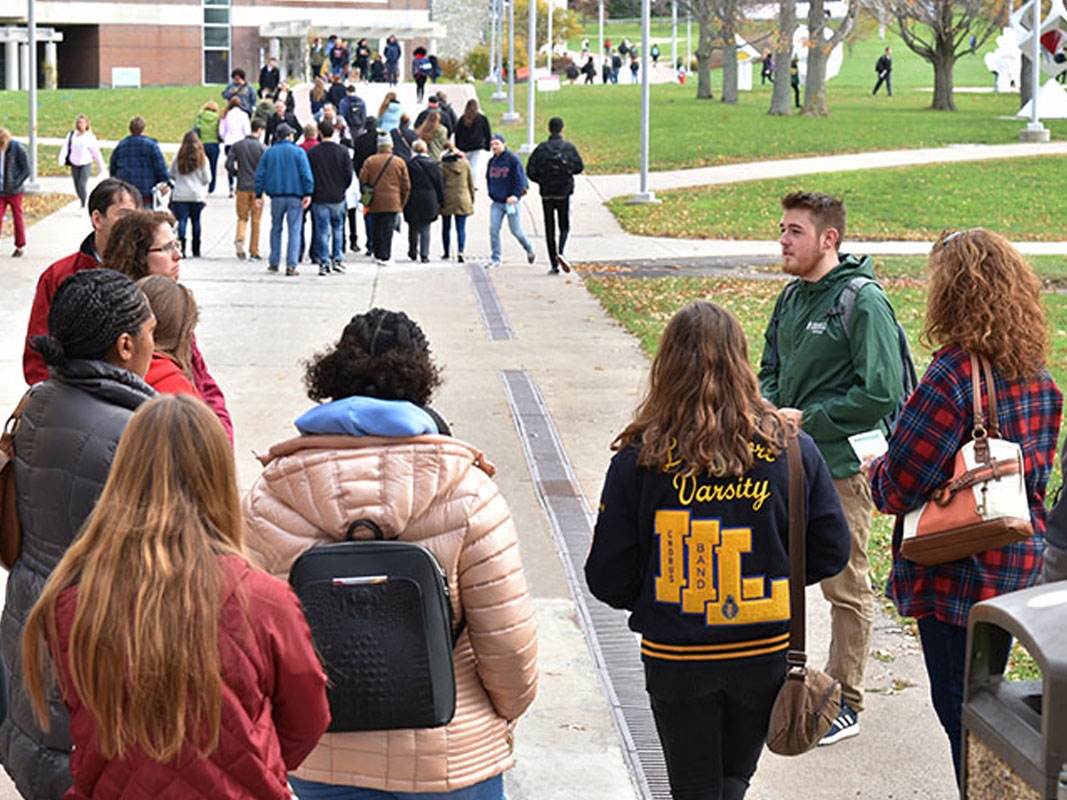 Groups of students walking outside on campus.
